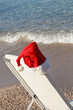 Santa Hat Hanging on Beach Chair. Space for text