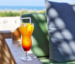 Orange cocktail on beach table
